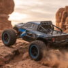 Yile Storm RC Truck - Desert Action Blue Yile Storm RC truck kicking up sand as it climbs a rock ledge in the desert
