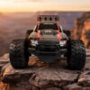Yile Storm RC Truck - Canyon Overlook Red and grey Yile Storm RC truck parked on a rock ledge above a canyon at sunset